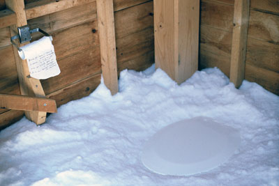 interior of toilet filled with snow and a toilet roll enscribed with text