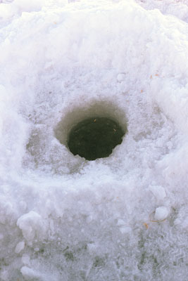 hole drilled in surface of frozen lake