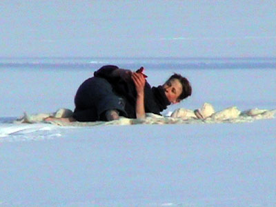 steward lying in snow on frozen lake
