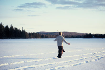 whithead walking across frozen lake balancing stick on his head